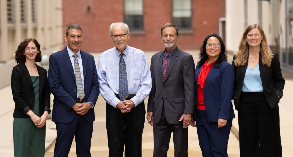 A photo of the firm's six attorneys outside their law office building.
